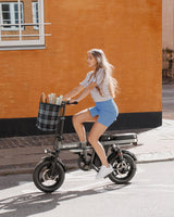 a woman riding a gray engwe t14 folding electric bike on the road